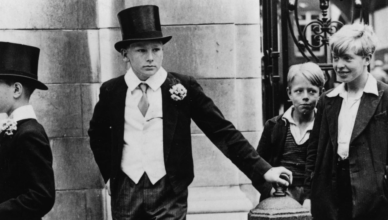 "Toff and Toughs" - 1937 photograph of five English boys: two dressed in the Harrow School uniform including waistcoat, top hat, and cane; and three nearby wearing the clothes of pre-war working class youths